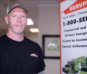 production tech male in a SERVPRO hat and a black SERVPRO t-shirt