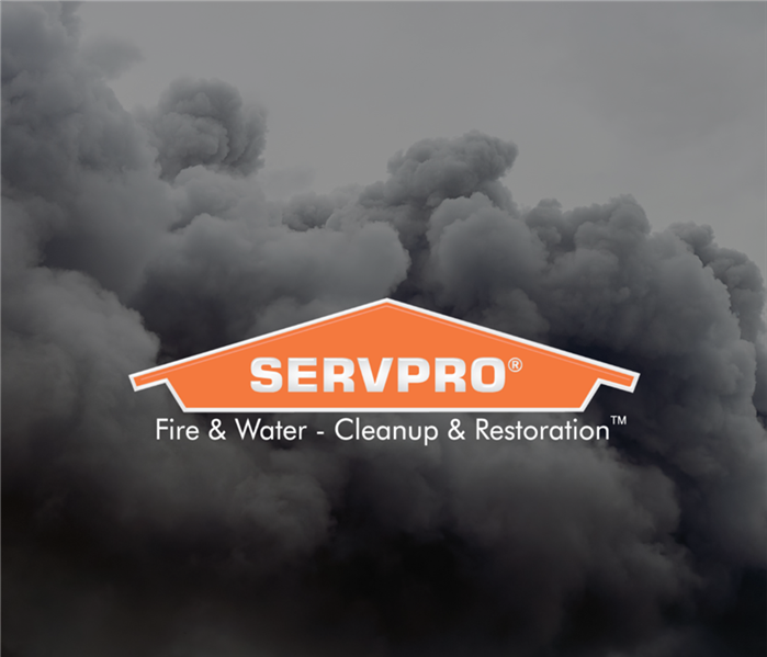 Dark grey smoke in a grey sky with the SERVPRO logo in the center